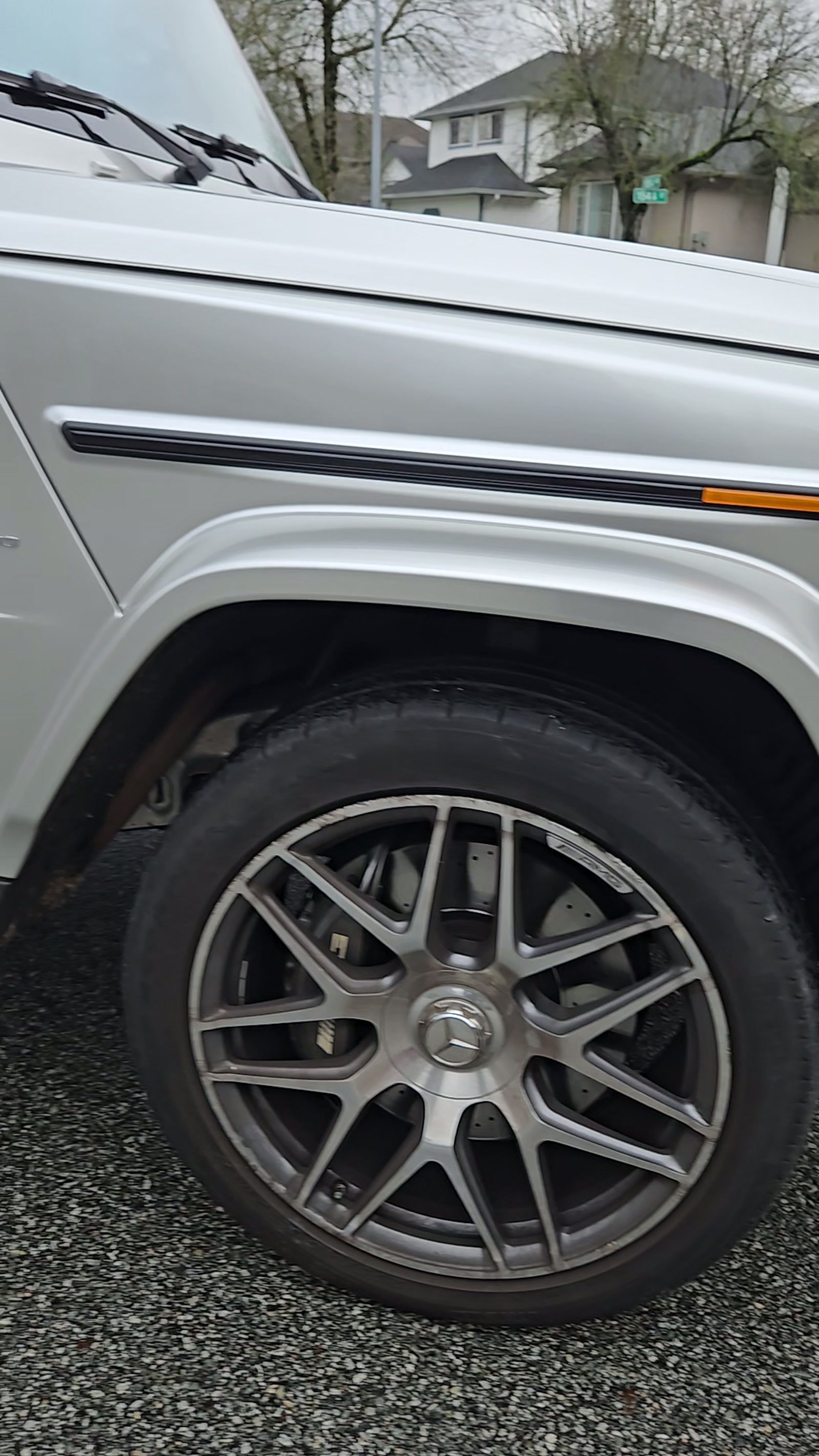 Satin grey vinyl wrap detail over the wheel arch of a Mercedes G-Class